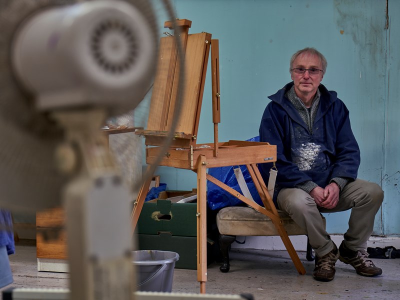 man sat with painting equipment