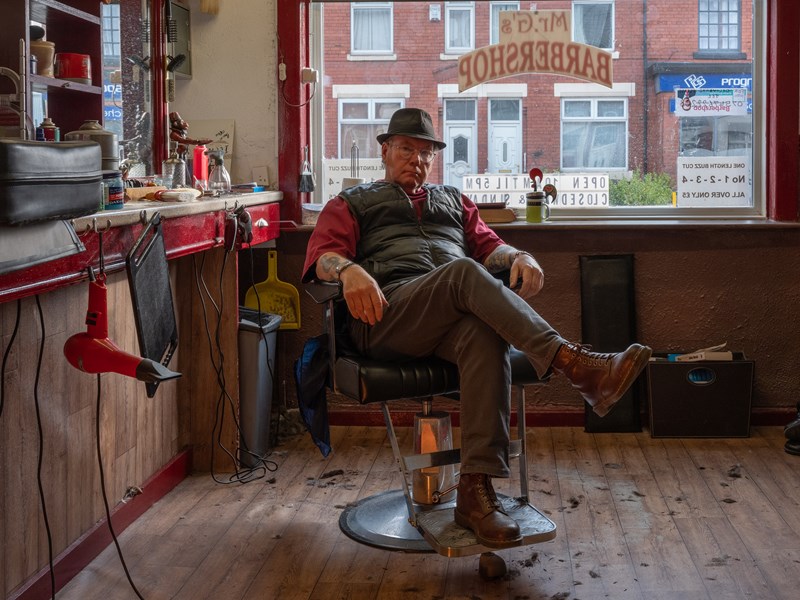 man sat in barber chair